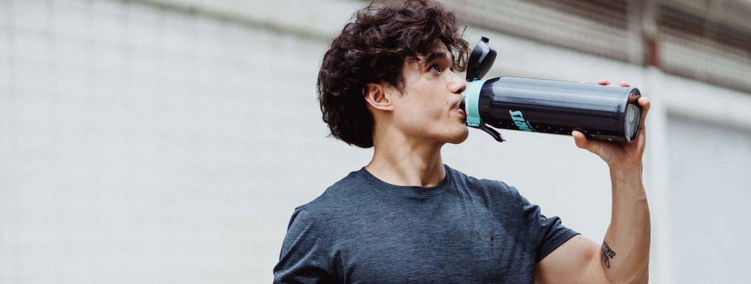 man drinking water at the gym